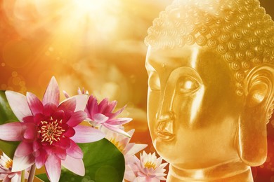 Beautiful golden Buddha sculpture and lotus flowers on color background