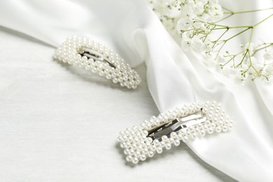 Beautiful hair clips and flowers on white table