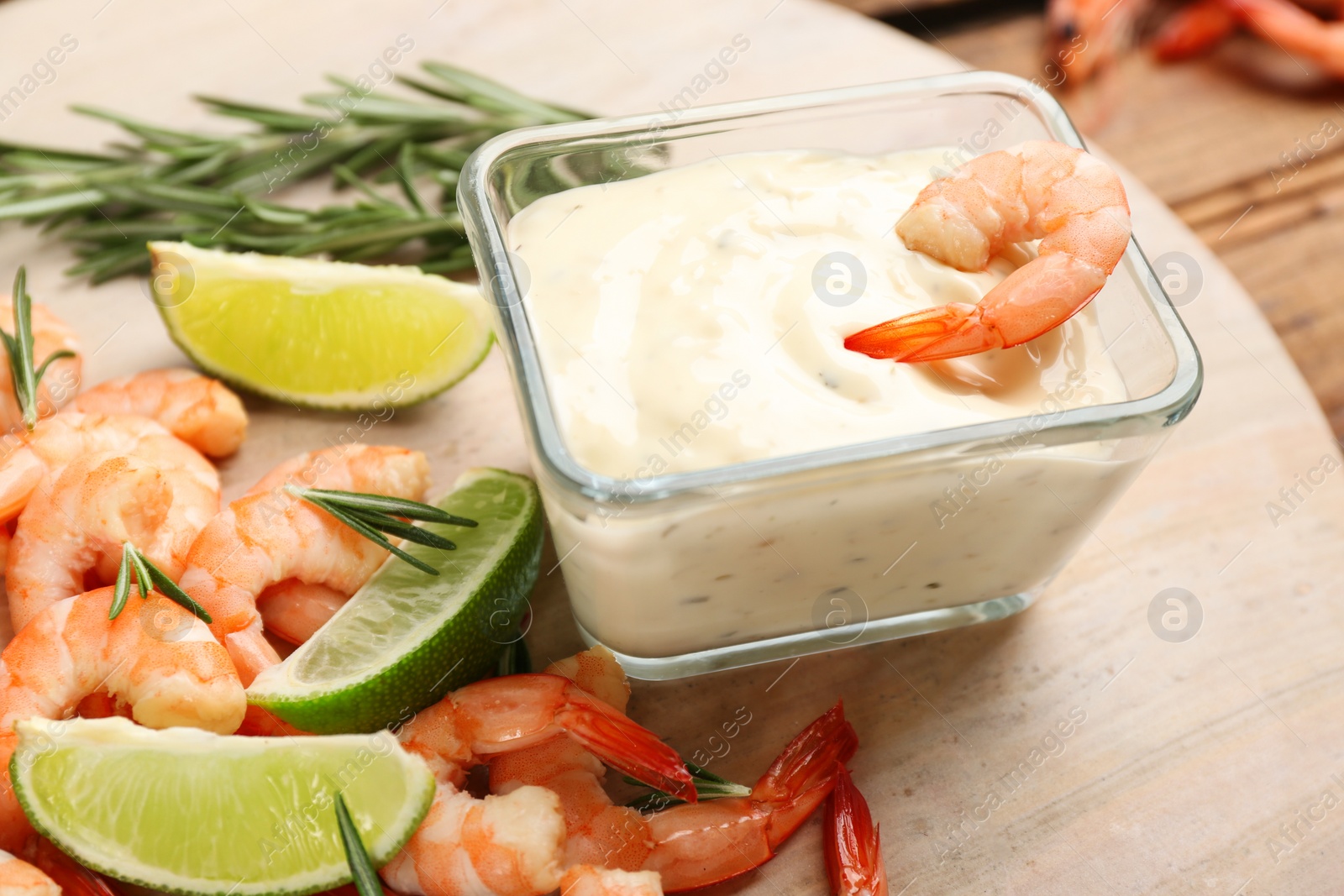 Photo of Delicious shrimp cocktail and tartar sauce on board, closeup