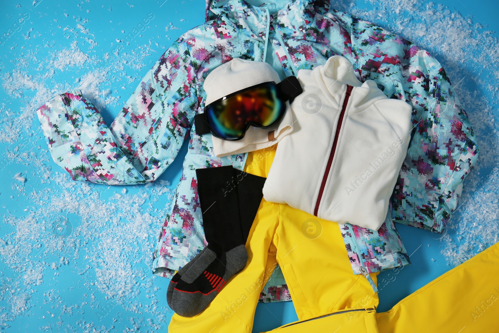 Photo of Stylish winter sport clothes on light blue background, flat lay