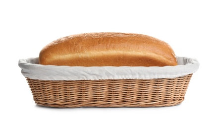 Photo of Loaf of tasty fresh bread in wicker basket on white background