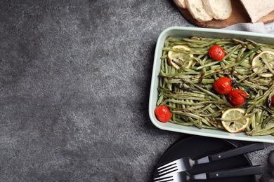 Photo of Flat lay composition with delicious baked green beans on grey table. Space for text