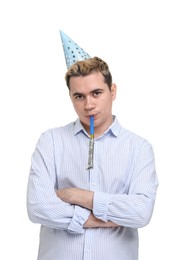 Sad young man with party hat and blower on white background