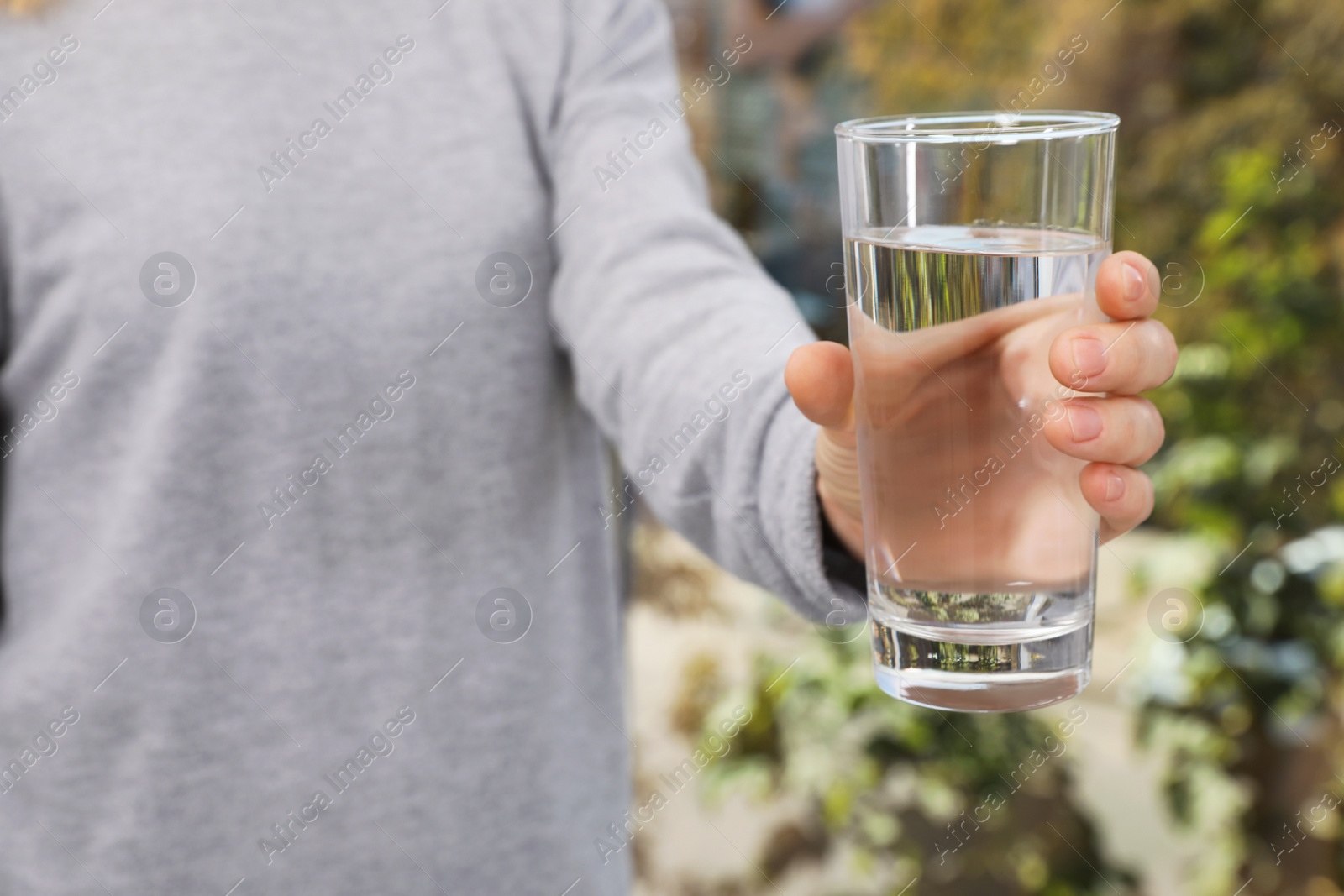 Photo of Woman holding glass of pure water, closeup