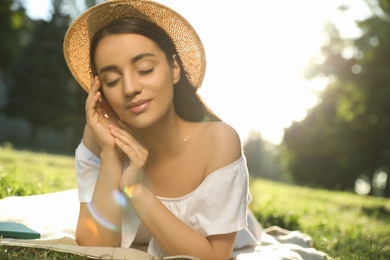 Beautiful young woman in park on sunny day