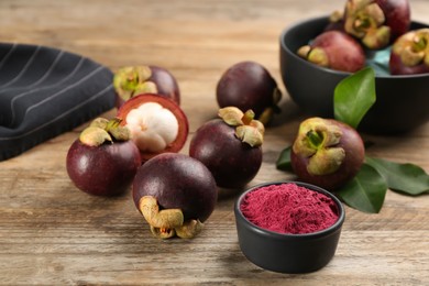 Purple mangosteen powder and fruits on wooden table