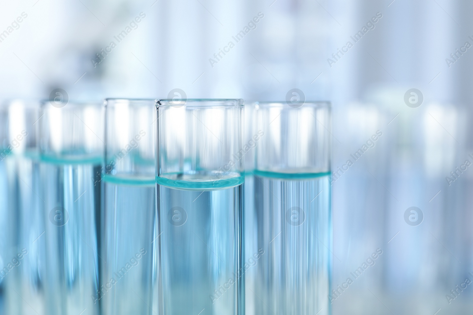 Photo of Test tubes with liquid on blurred background, closeup. Laboratory analysis