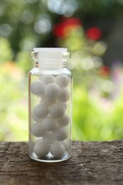 Photo of Bottle of homeopathic remedy on wooden table, closeup