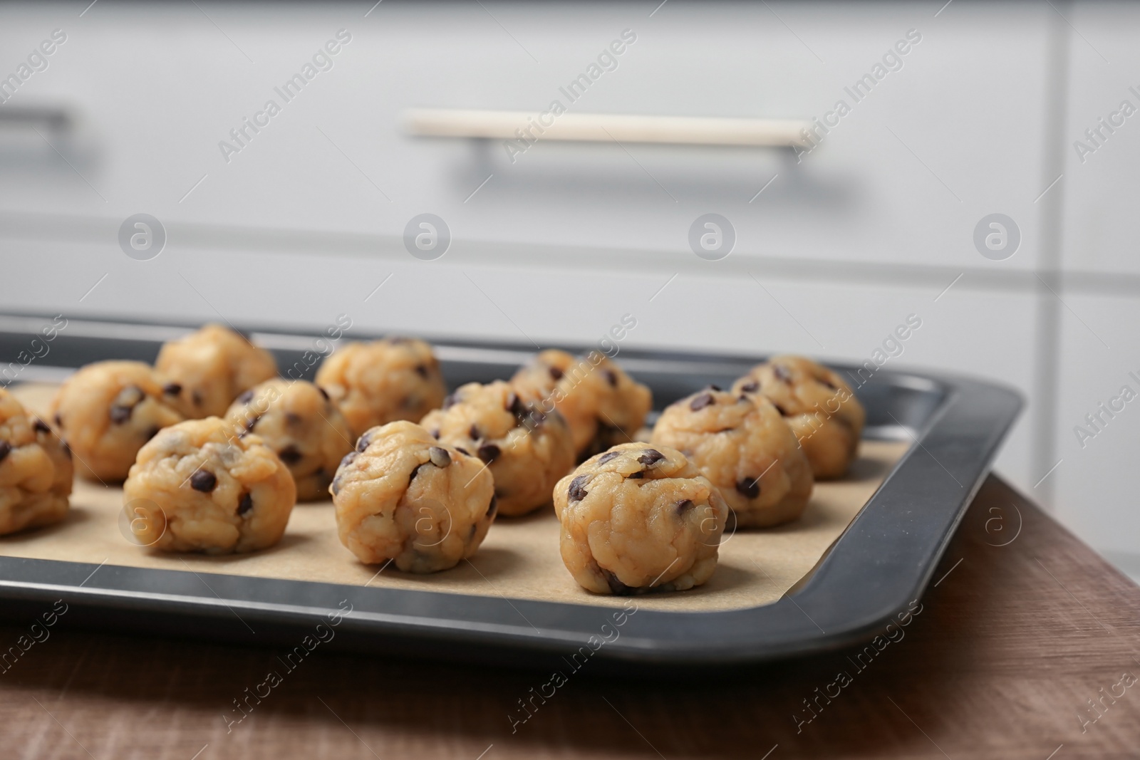 Photo of Raw cookie dough with chocolate chips on baking sheet