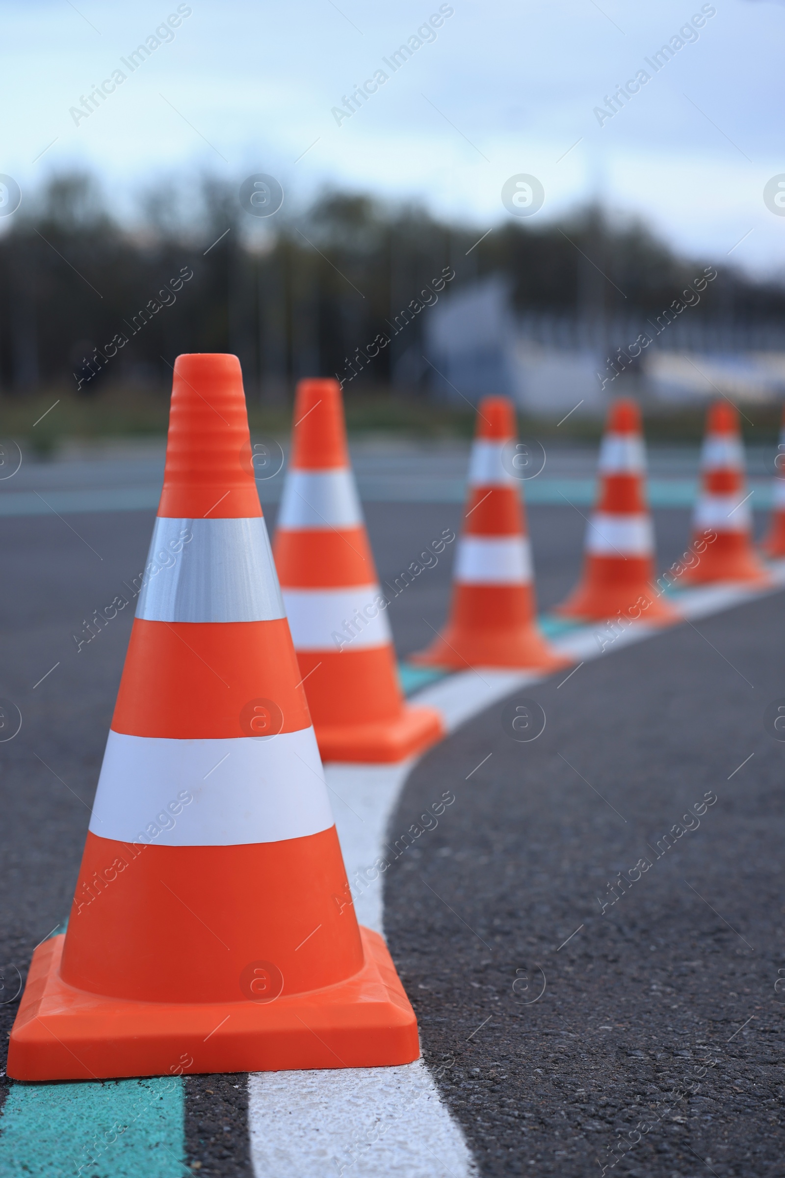 Photo of Driving school test track with marking lines, focus on traffic cone