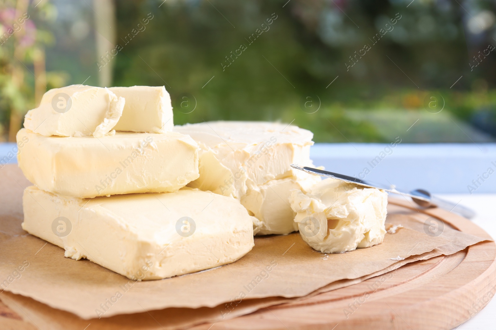 Photo of Tray with tasty homemade butter and knife on white wooden windowsill