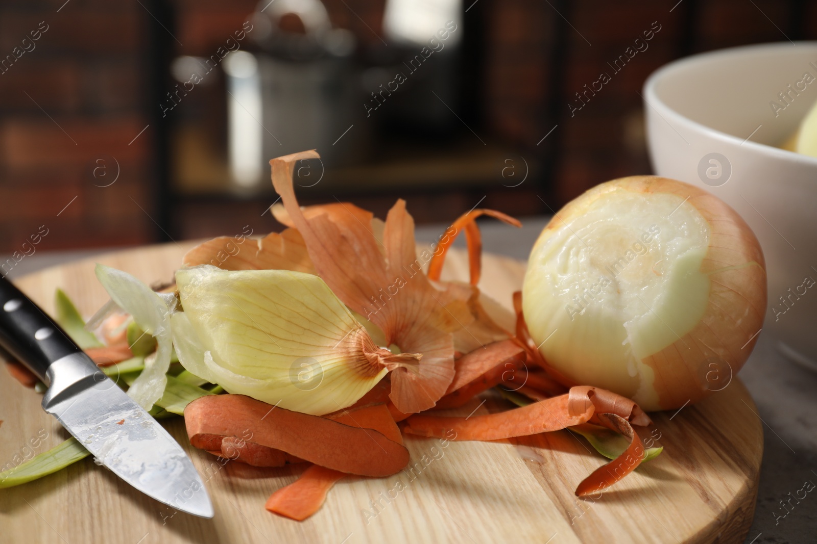 Photo of Peels of fresh vegetables and knife on table indoors