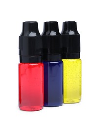 Bottles with different food coloring on white background