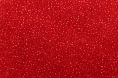 Photo of Bright red glass beads as background, top view