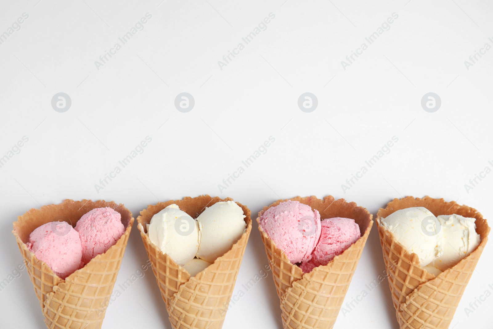 Photo of Delicious ice creams in wafer cones on white background, top view