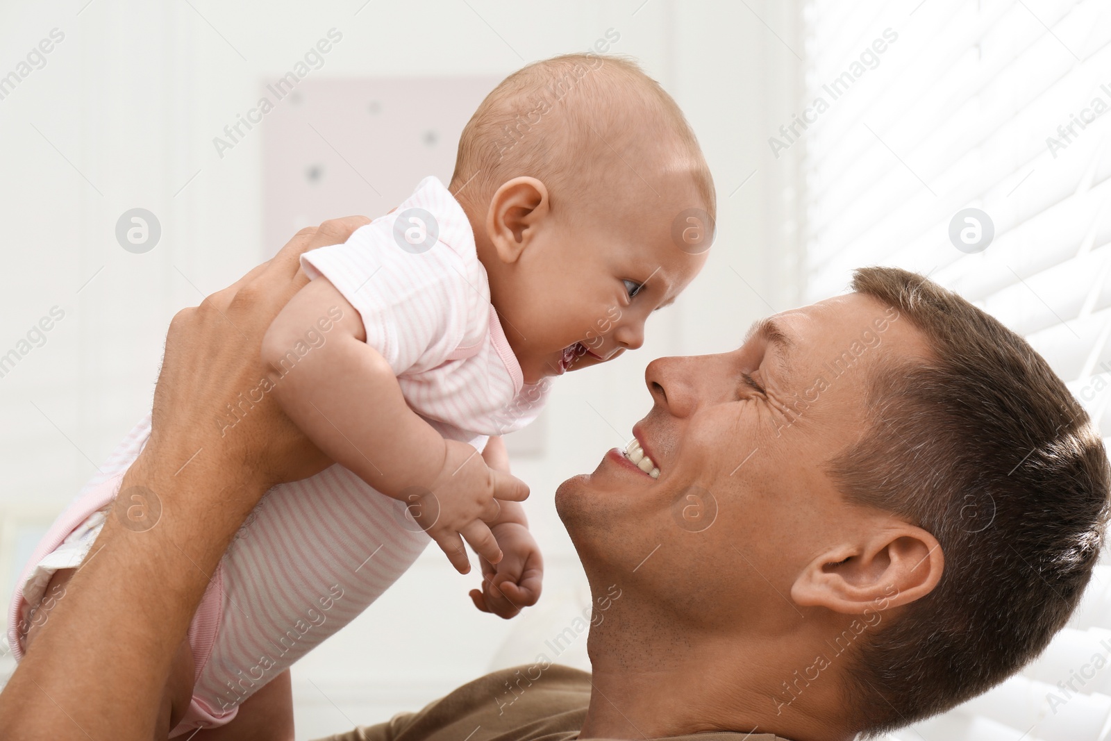 Photo of Happy father with his little baby at home