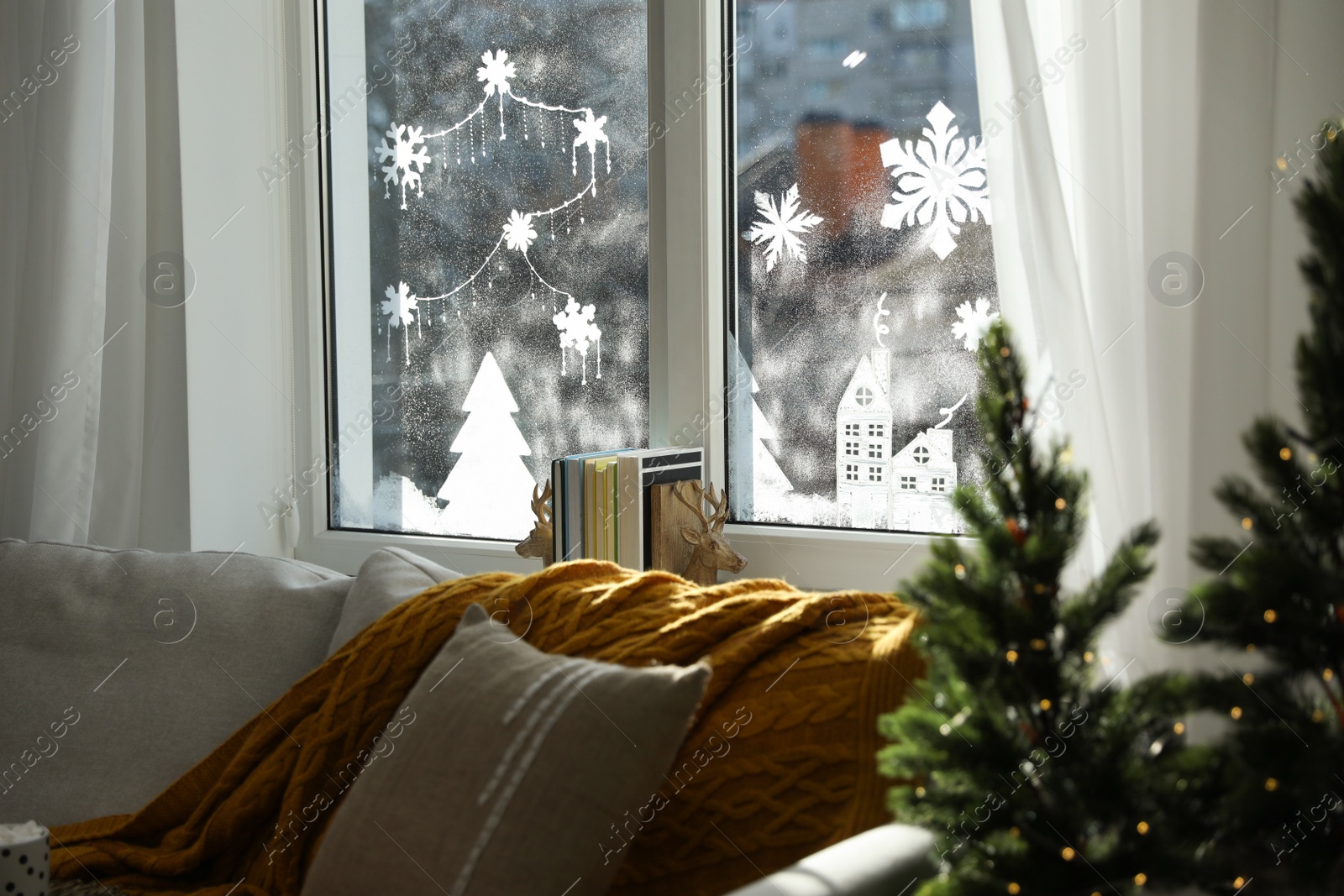 Photo of Beautiful drawing made of artificial snow on window at home. Christmas decor