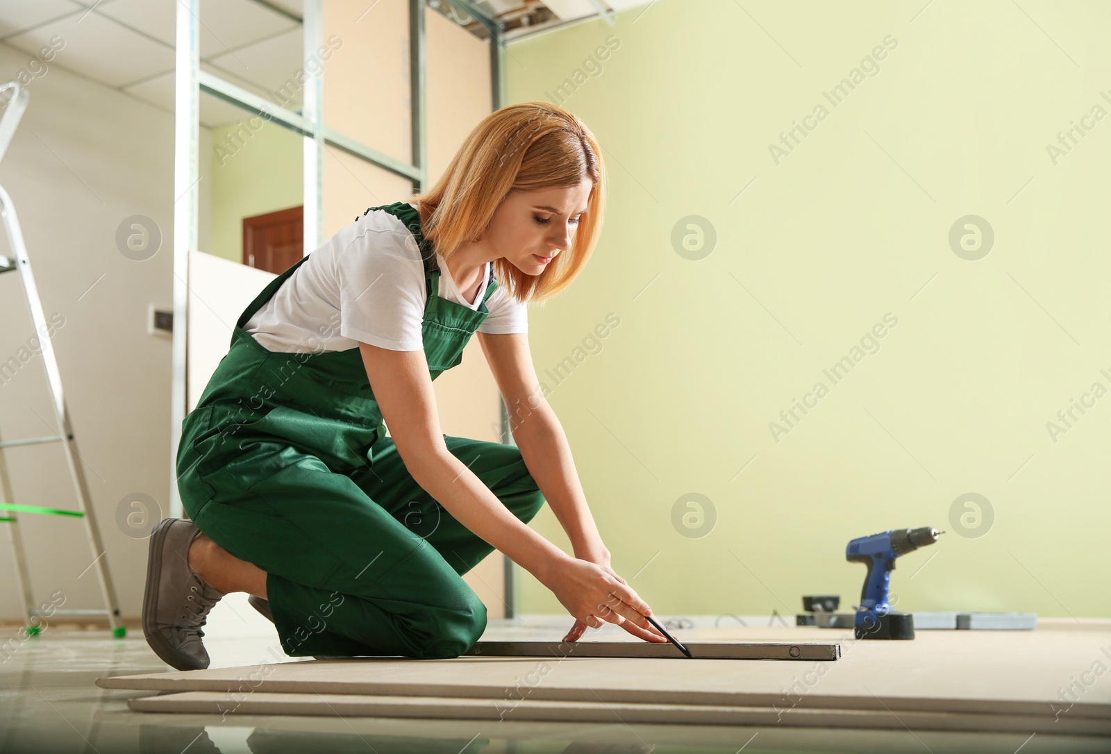 Photo of Professional builder working with drywall indoors. Home repair service