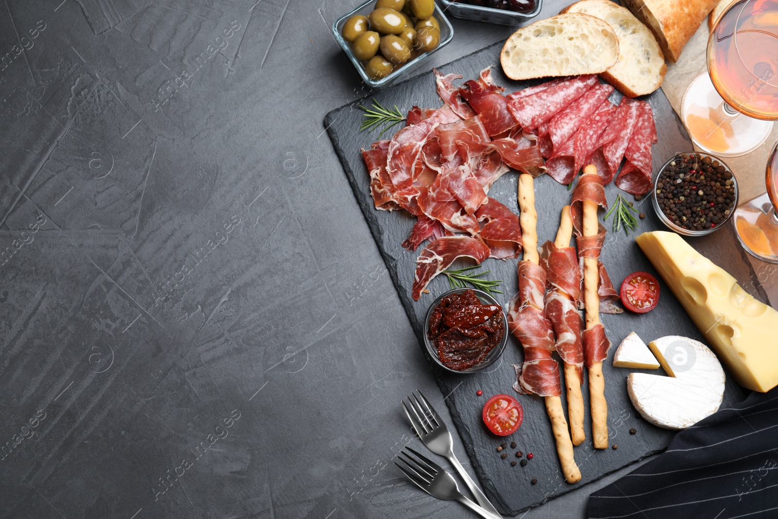 Photo of Tasty prosciutto served on grey table, flat lay. Space for text