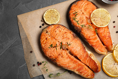 Delicious roasted fish on grey table, flat lay