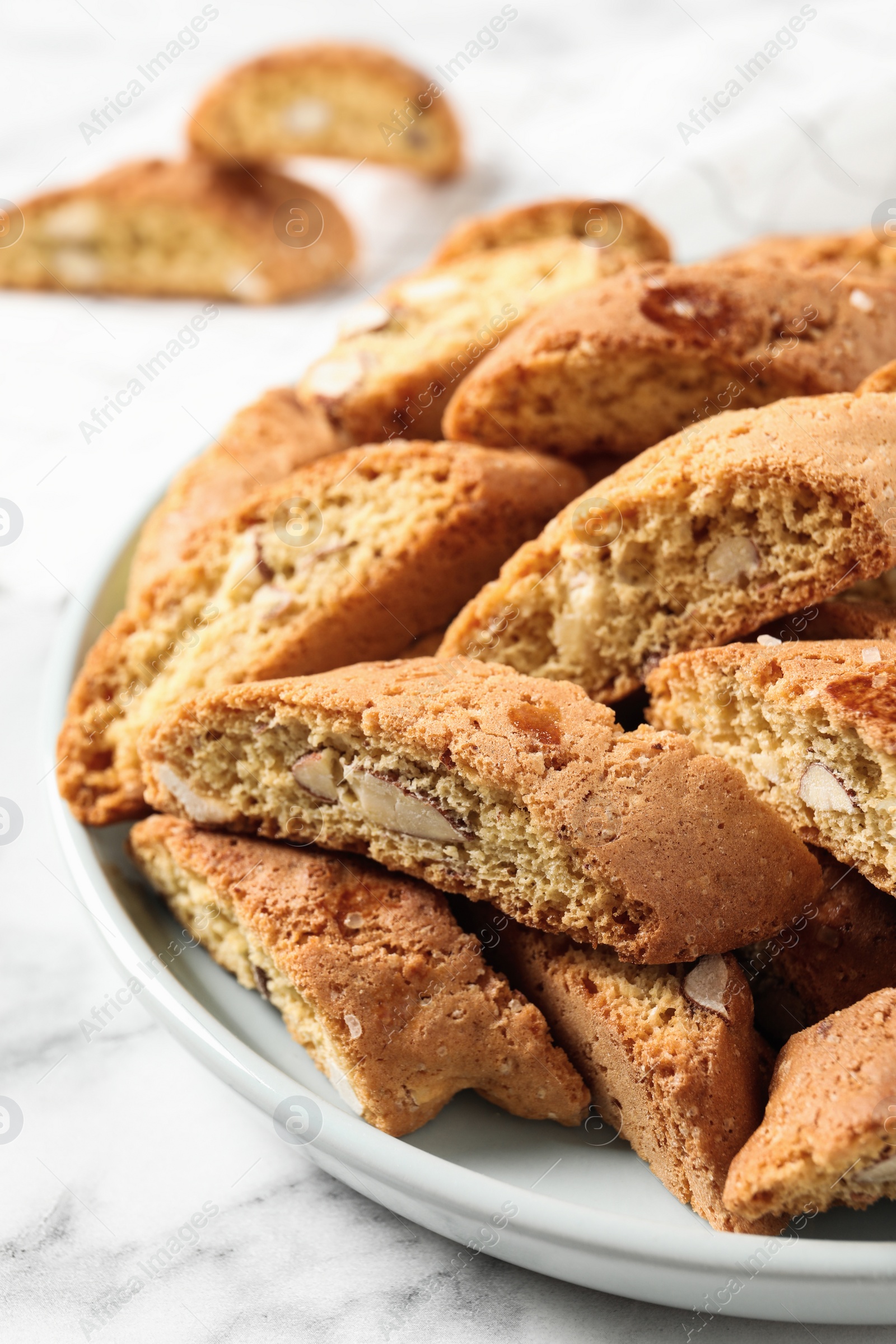 Photo of Traditional Italian almond biscuits (Cantucci) on white marble table, closeup