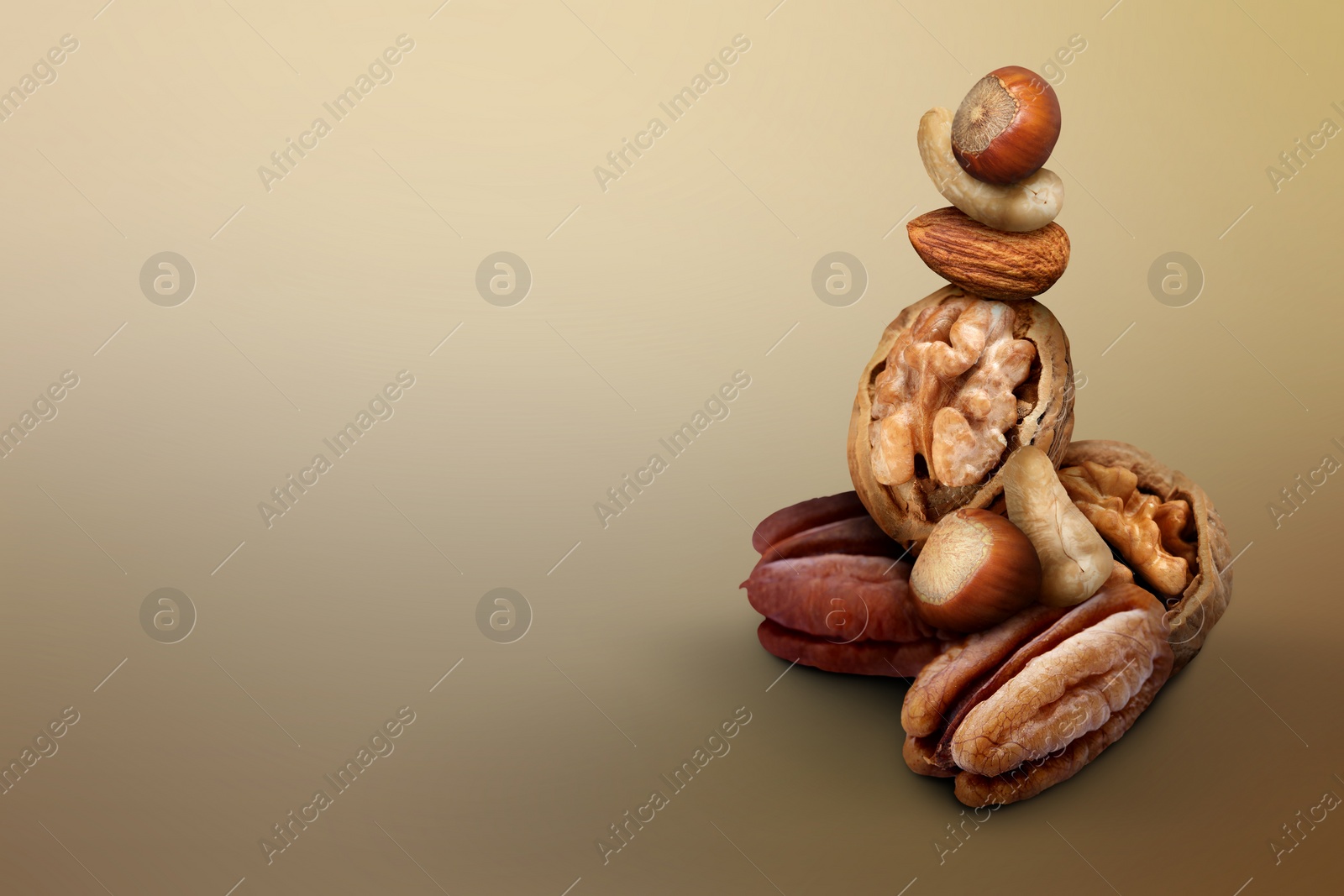 Image of Many different nuts on light brown gradient background, space for text