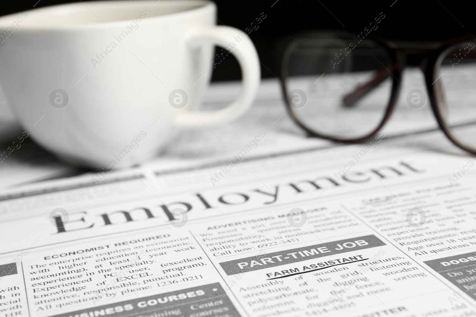 Photo of Cup and glasses on newspaper. Search concept