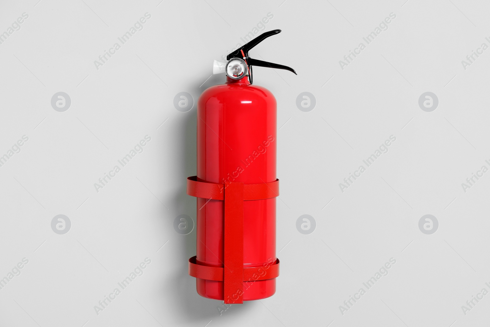 Photo of Red fire extinguisher on light green background