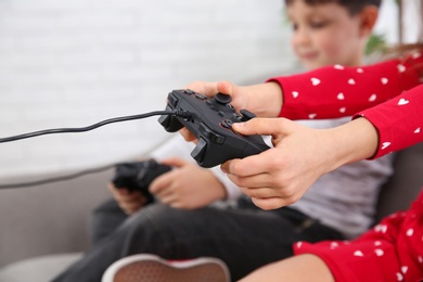 Children playing video game at home, closeup