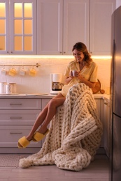 Photo of Beautiful young woman enjoying coffee in kitchen. Weekend morning