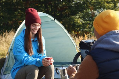 Photo of Tourists with mugs of coffee at campsite in morning