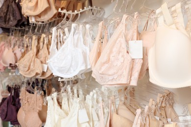 Photo of Many different beautiful women's underwear in lingerie store, closeup