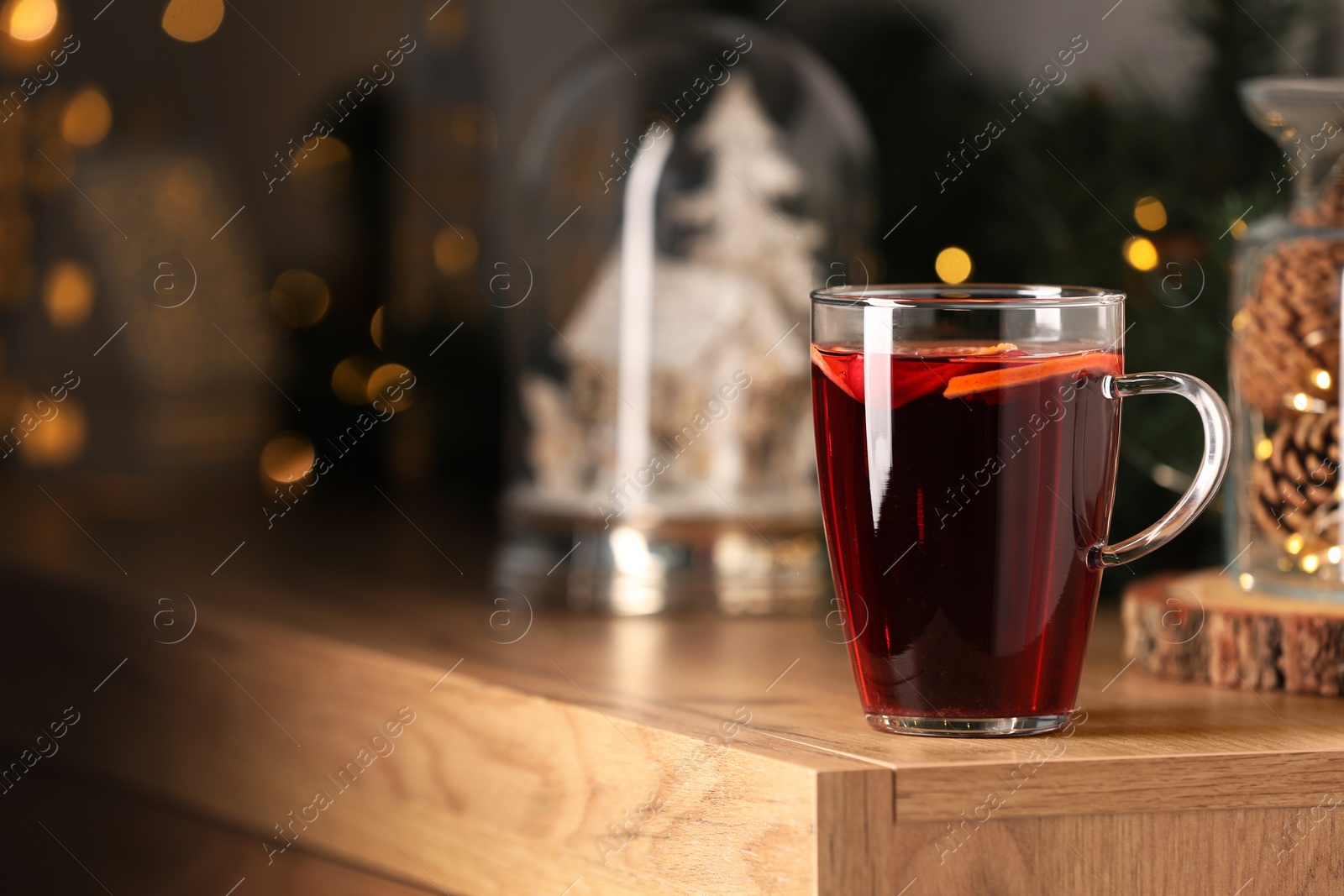 Photo of Delicious mulled wine in glass cup on wooden table. Space for text