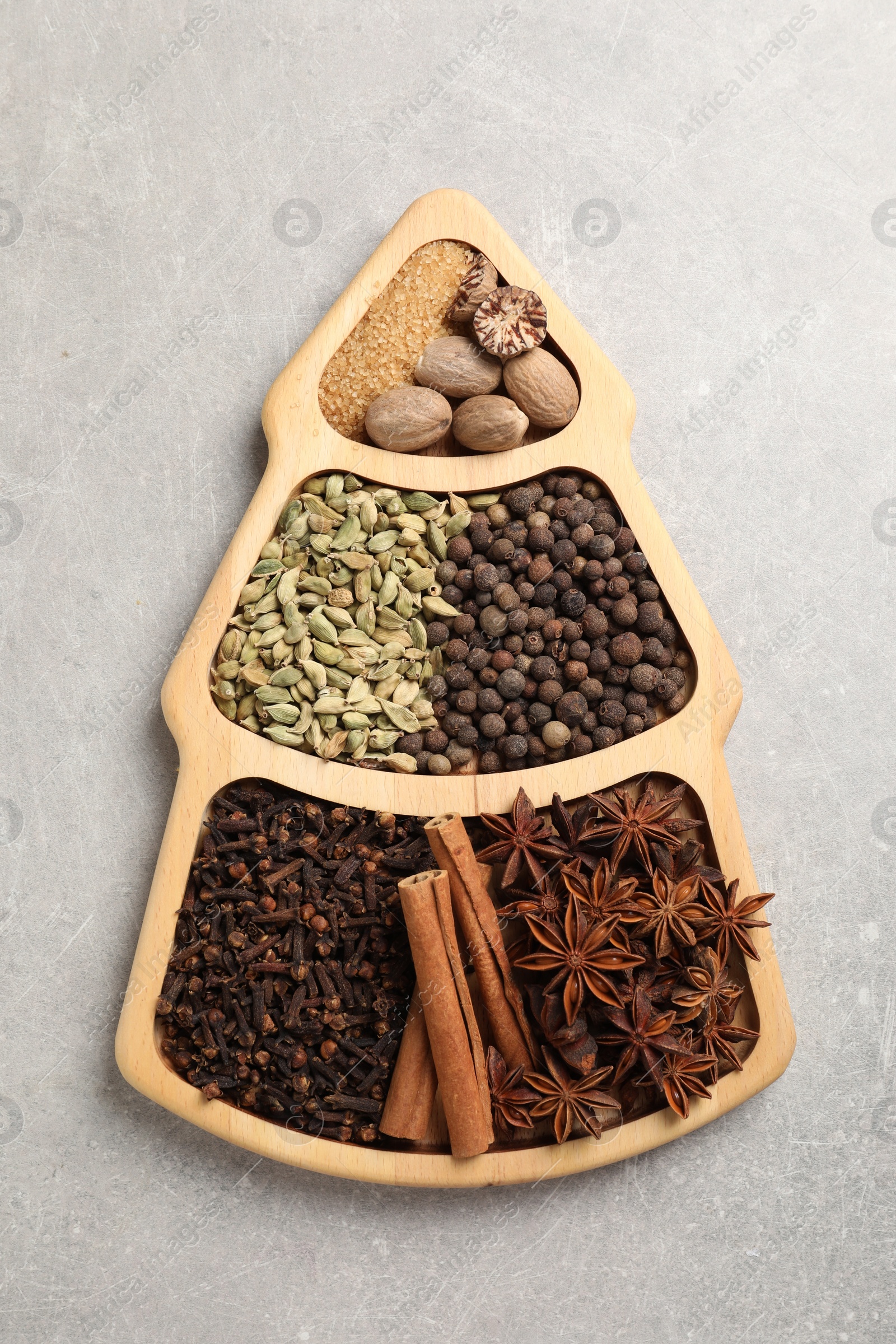 Photo of Different spices and nuts on gray textured table, top view