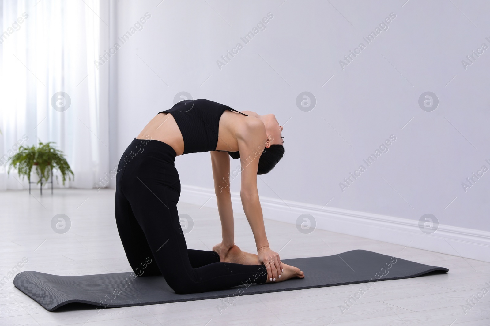 Photo of Professional young acrobat practicing yoga at home