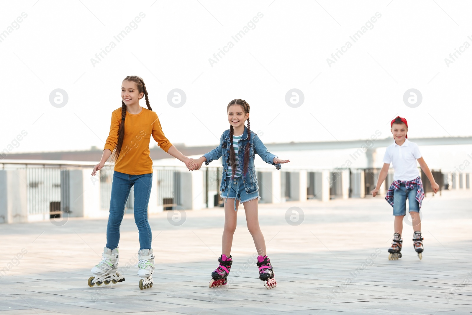 Photo of Little children roller skating on city street