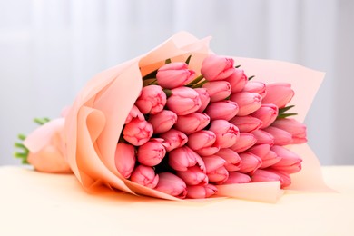 Photo of Bouquet of beautiful pink tulips on beige background, closeup