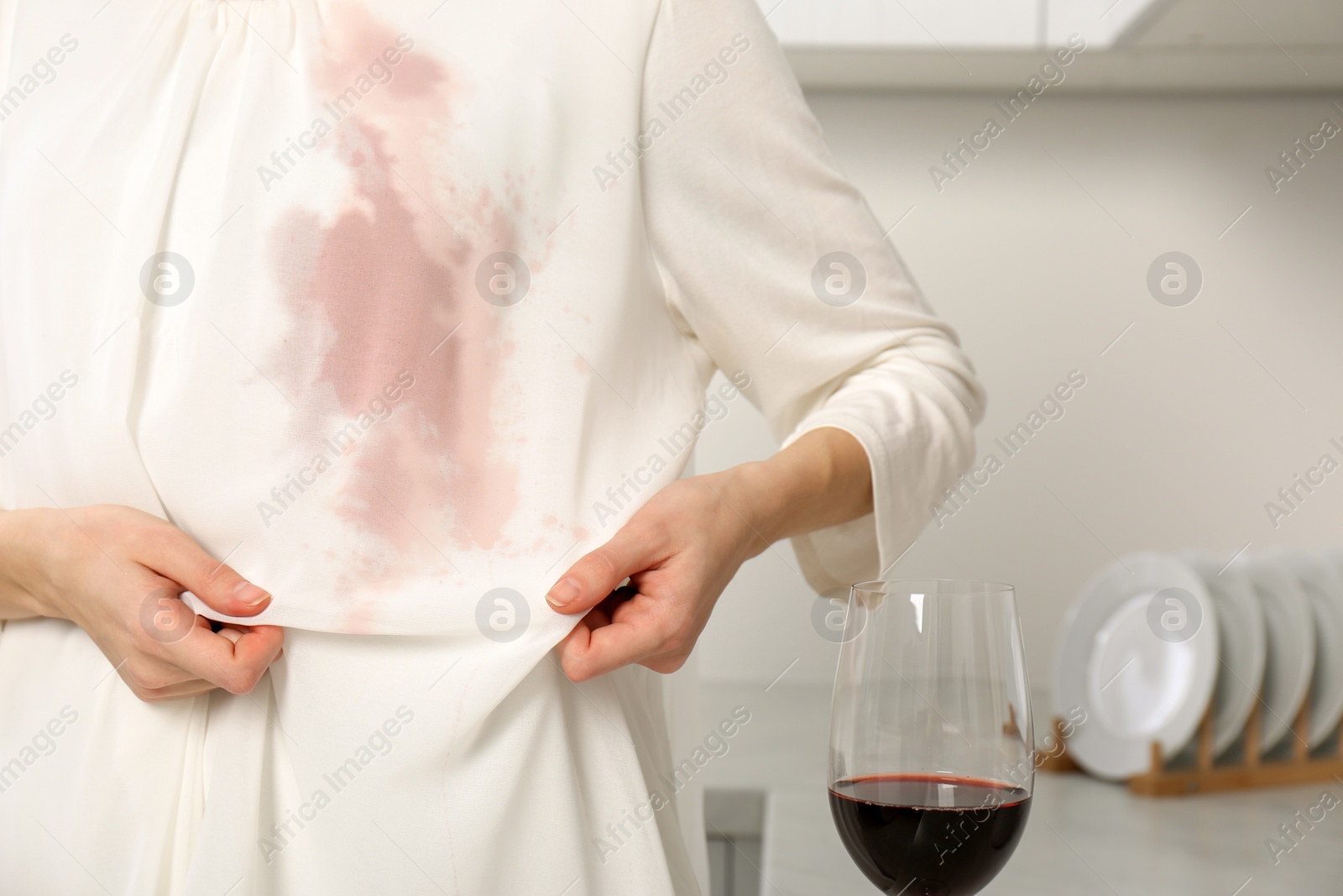 Photo of Woman with wine stain on her clothes indoors, closeup