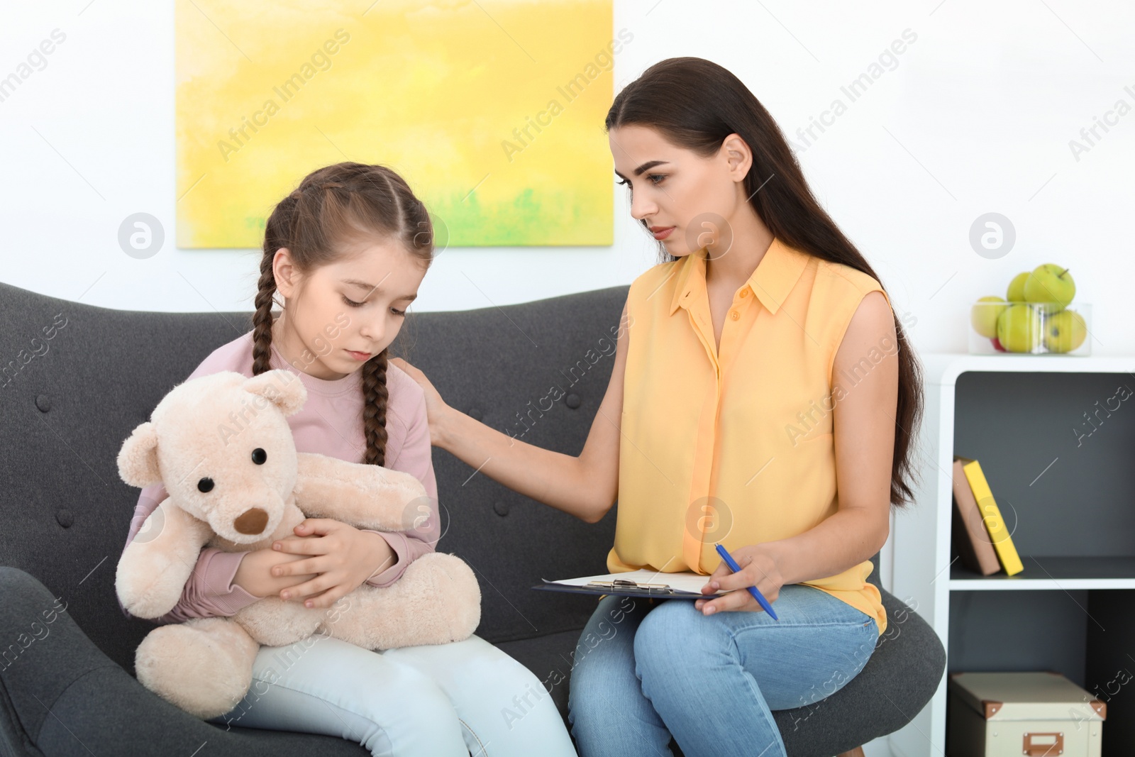 Photo of Child psychologist working with little girl in office