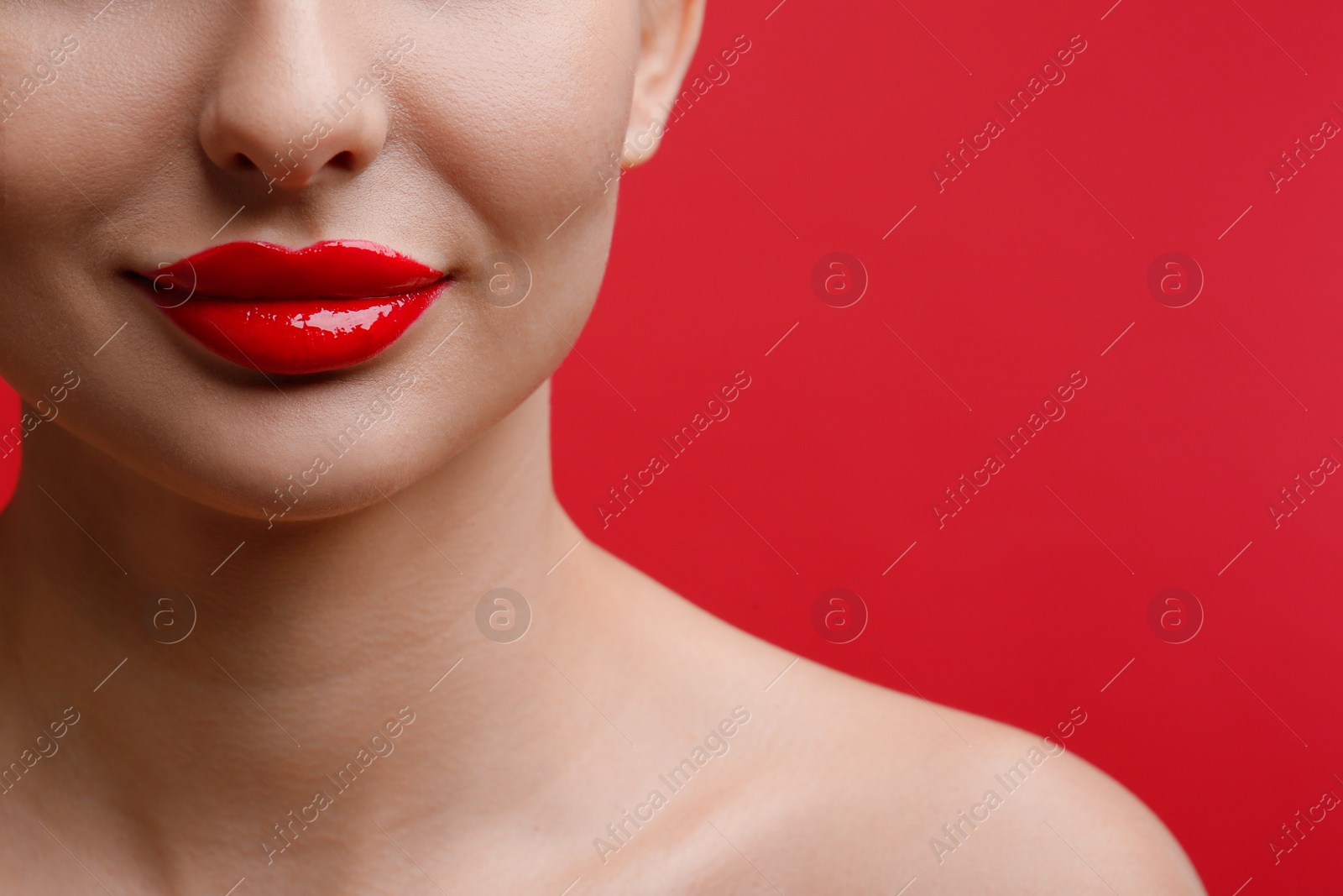 Photo of Closeup view of woman with beautiful lips on red background. Space for text