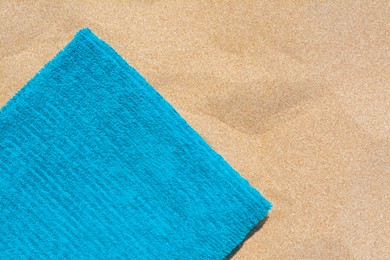 Soft blue beach towel on sand, top view. Space for text