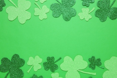 Photo of Decorative clover leaves on green background, flat lay with space for text. Saint Patrick's Day celebration