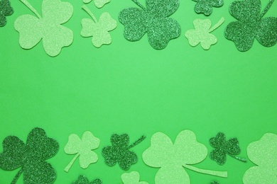 Decorative clover leaves on green background, flat lay with space for text. Saint Patrick's Day celebration