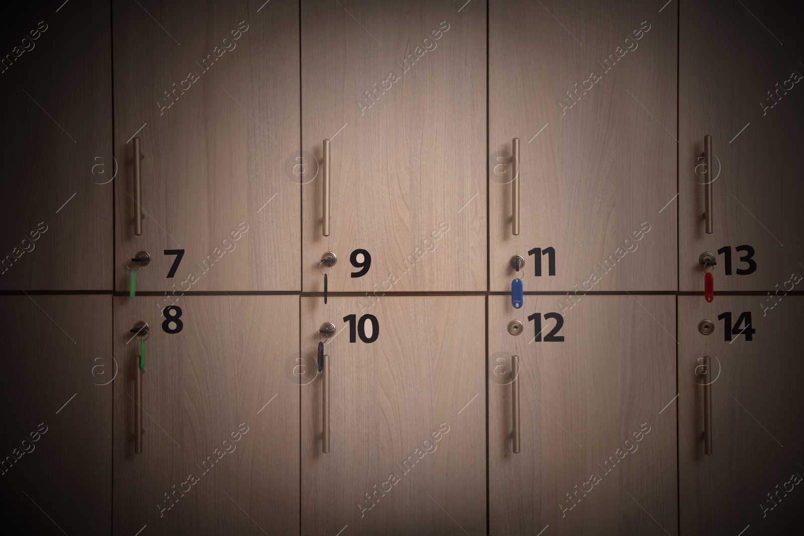 Image of Many wooden lockers with keys and numbers on doors. Vignette effect