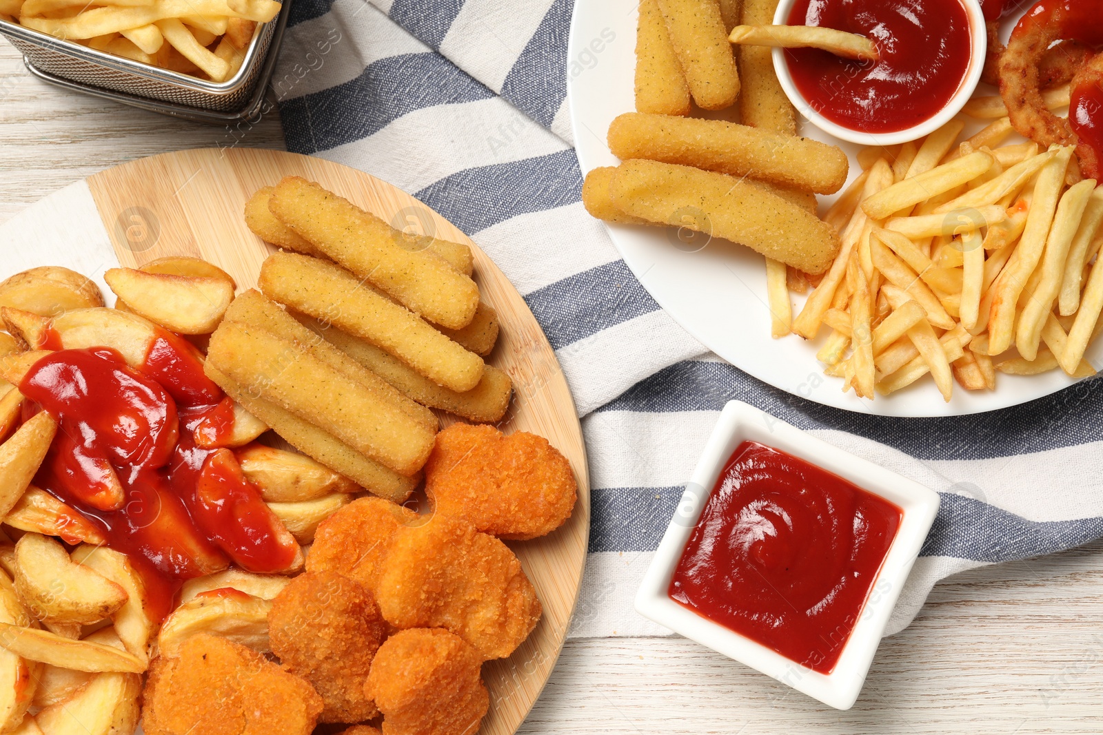 Photo of Different snacks and tasty ketchup on wooden table, flat lay