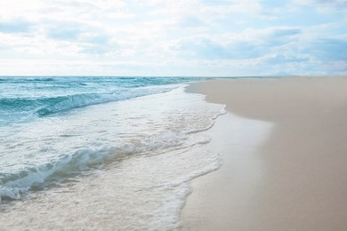 Photo of Sea waves rolling onto sandy tropical beach