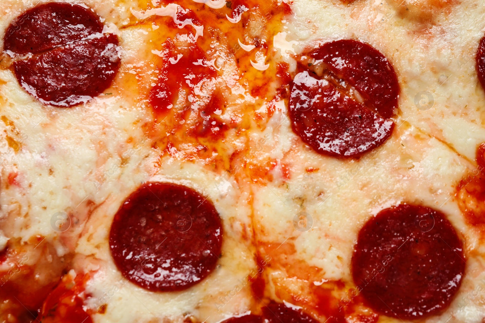 Photo of Hot delicious pepperoni pizza with melted cheese, closeup