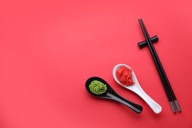 Photo of Swirl of wasabi paste, pickled ginger and chopsticks on red background, flat lay. Space for text