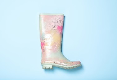 Photo of Colorful rubber boot on light blue background, top view