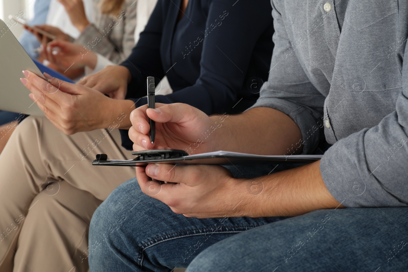 Photo of Man with clipboard waiting for job interview in office, closeup